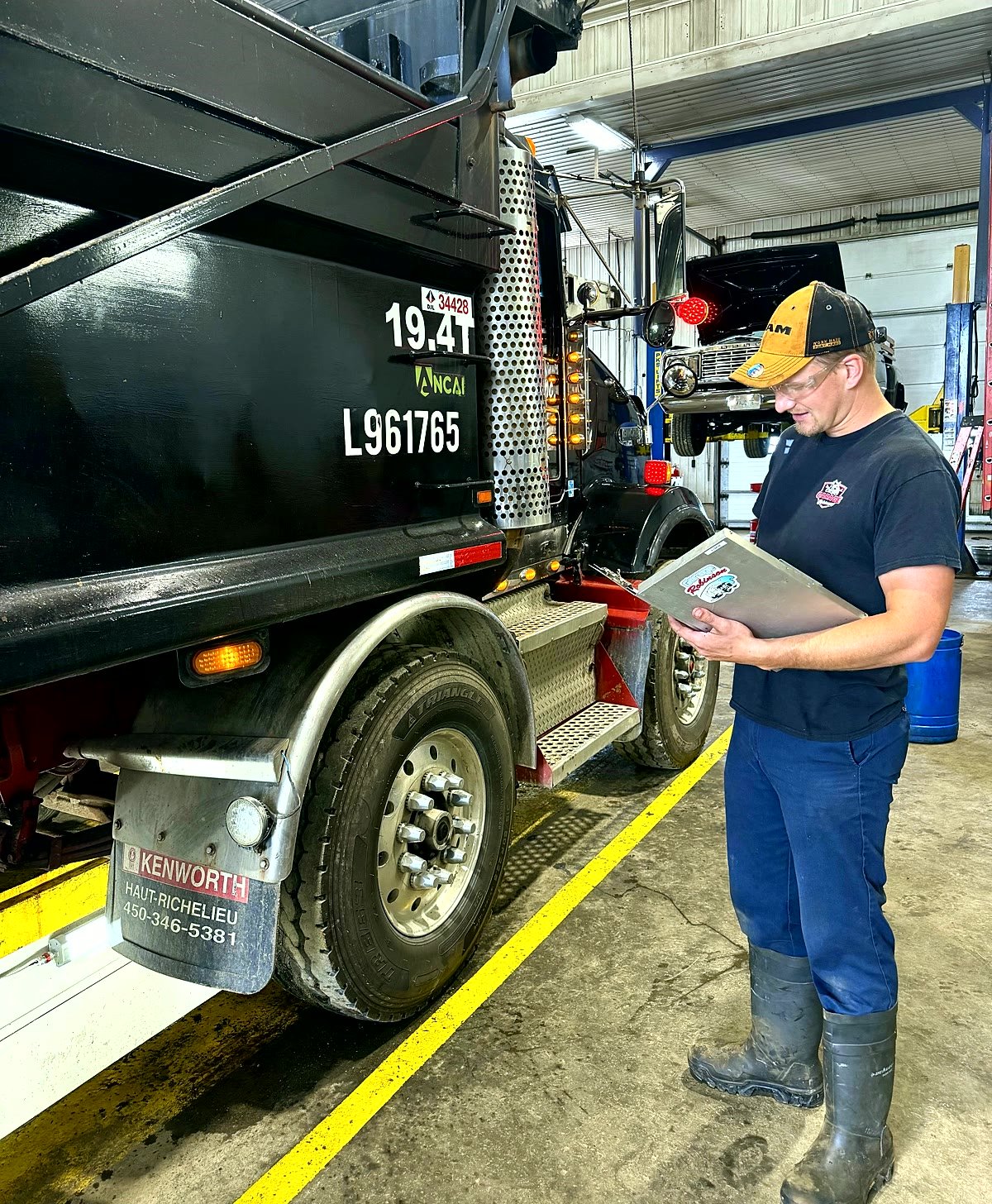 Technicien effectuant une inspection mécanique complète d'un camion Kenworth